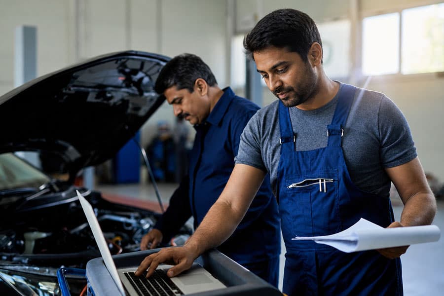 Technicians inspecting a vehicle in an automotive workshop